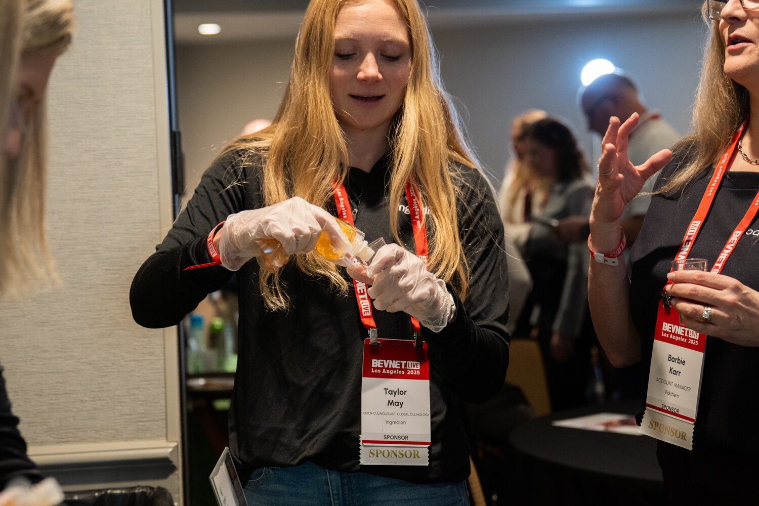 Attendees wearing food-service gloves prepare and taste samples.