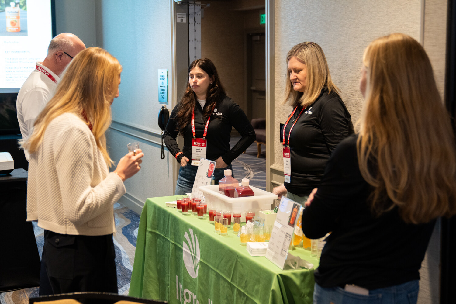 Staff stand behind a green Ingredion table with samples.
