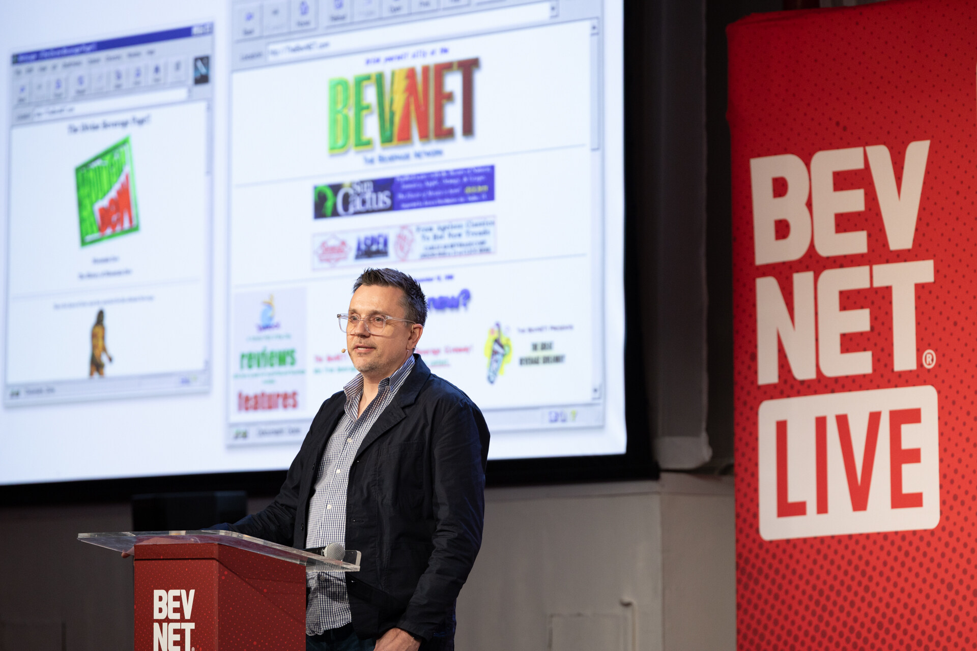 Speaker at a podium beside a large screen showing a vintage BevNET web page, next to a red BevNET Live banner.