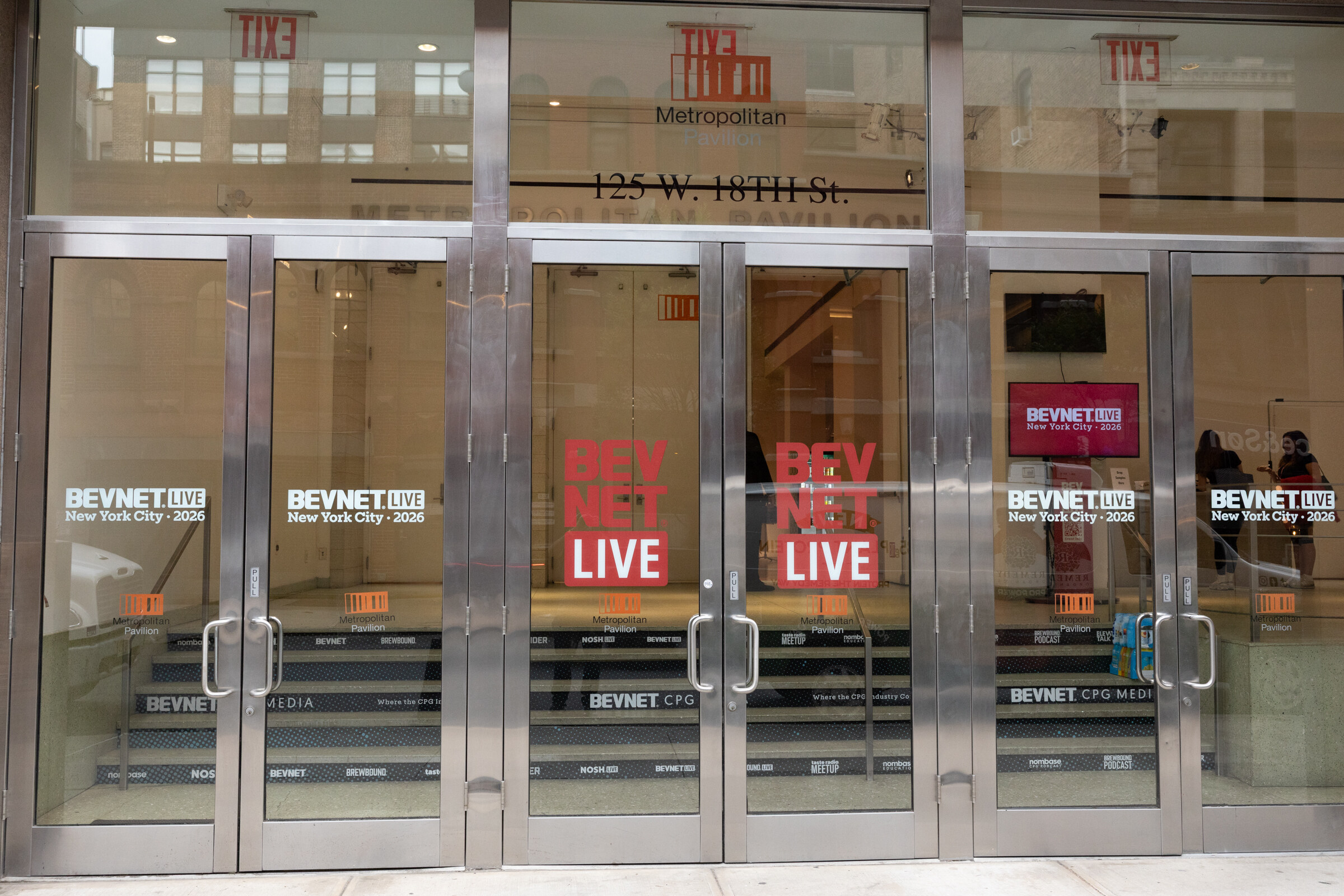 Glass entrance doors at 125 W. 18th St. decorated with BevNET Live New York City 2026 decals.