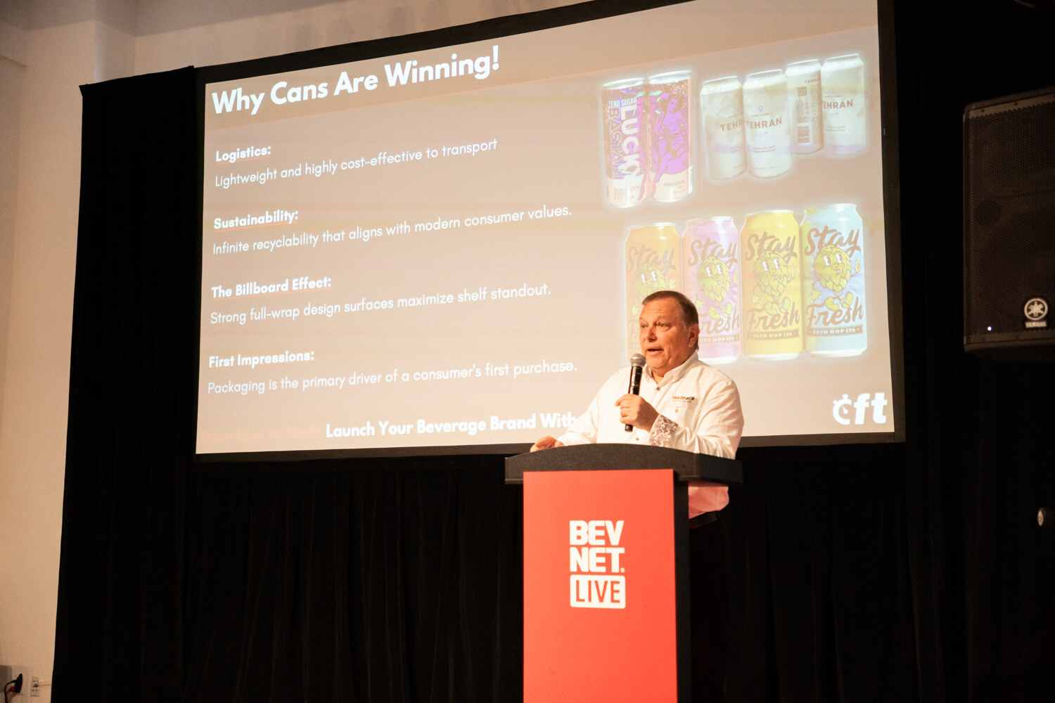 Speaker at a red BevNET Live podium under a slide titled “Why Cans Are Winning!” showing printed cans.