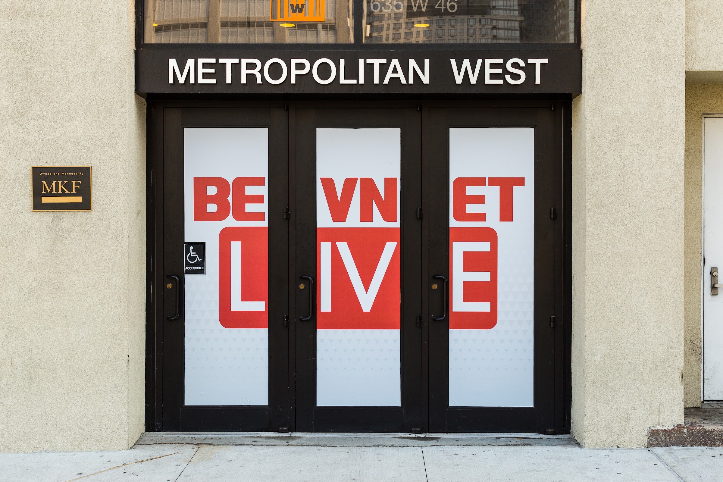 Entrance doors under a Metropolitan West sign covered in large red and white BEVNET LIVE graphics.
