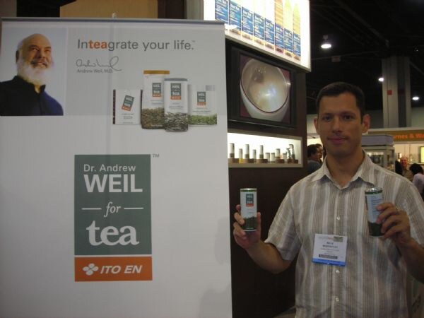 A man in a striped shirt holds two canned teas beside a Dr. Andrew Weil for Tea and Ito En banner reading "Inteagrate your life."