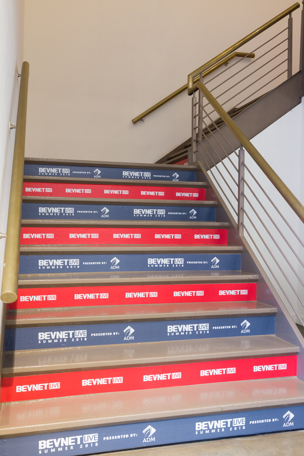 A staircase whose risers show alternating red and blue BevNET Live Summer 2018 graphics.