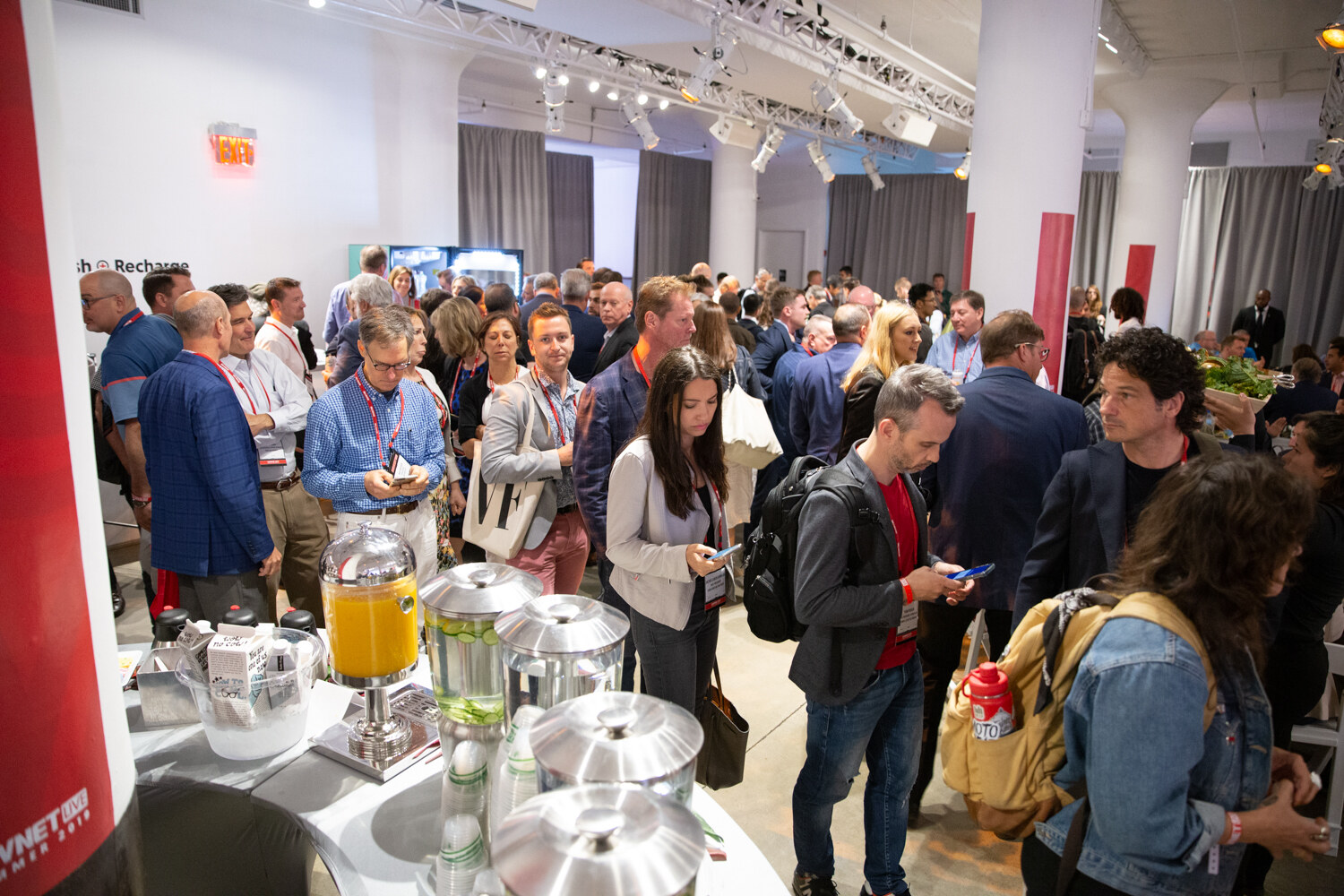 Crowd of attendees lining up at a beverage station in the networking room.