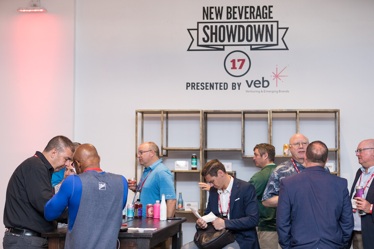 Attendees at tables beneath a New Beverage Showdown sign presented by veb.