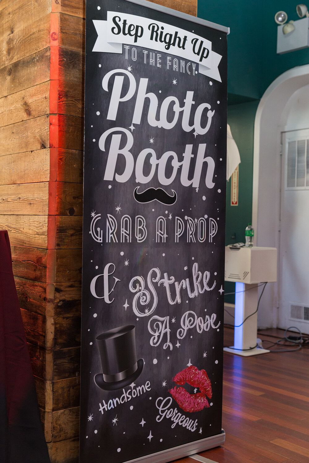 Chalkboard-style photo booth sign reading Step right up to the fancy photo booth.