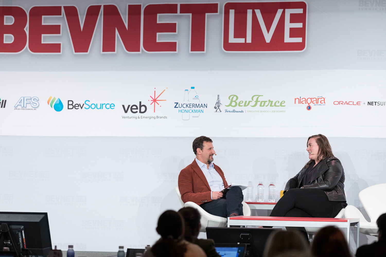 Wide view of the fireside chat on the BevNET Live stage with audience heads in the foreground.