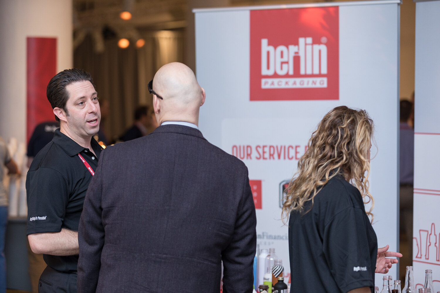 Berlin Packaging staff talking with an attendee at the company's banner stand.