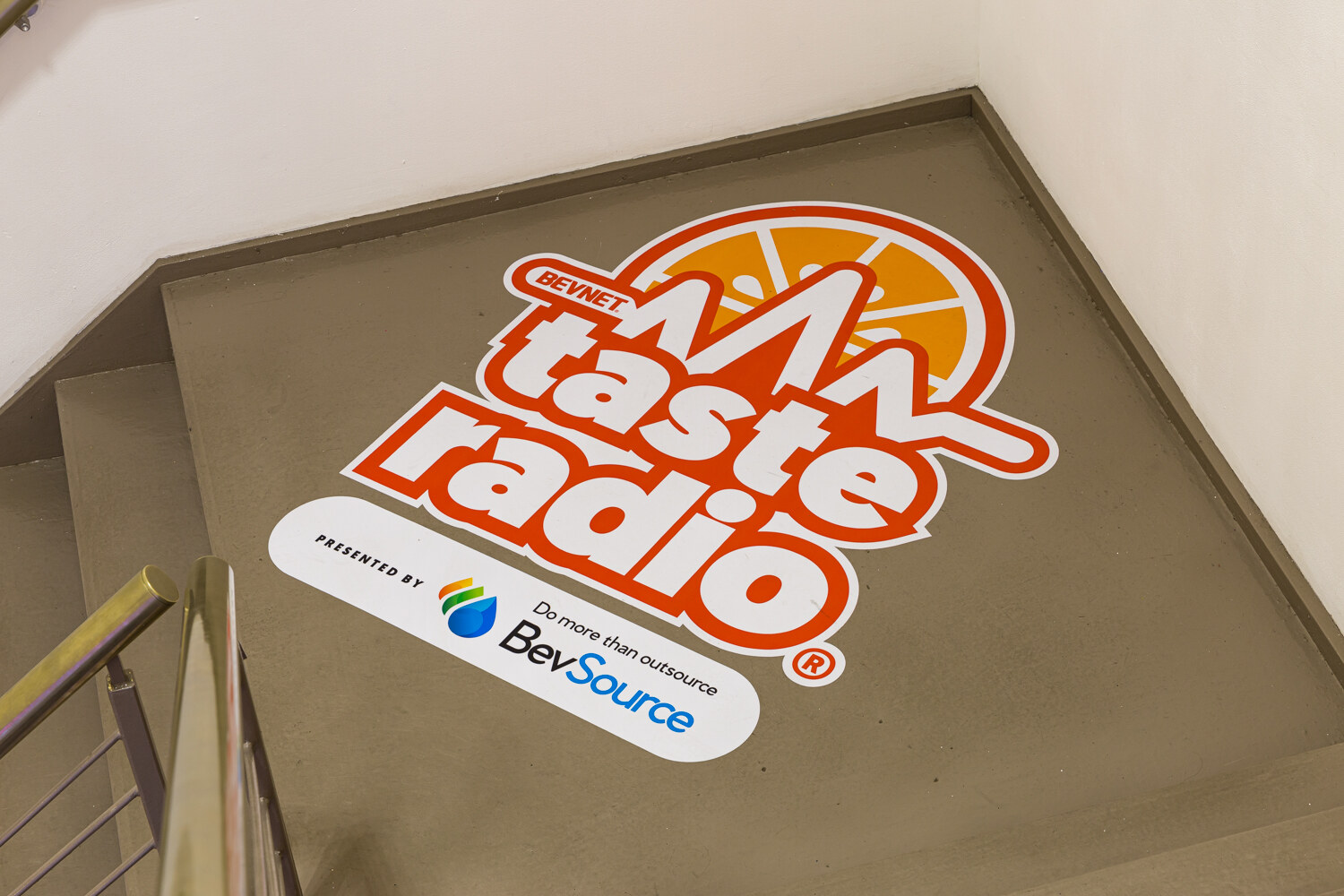 Taste Radio logo decal presented by BevSource on a stairway landing.