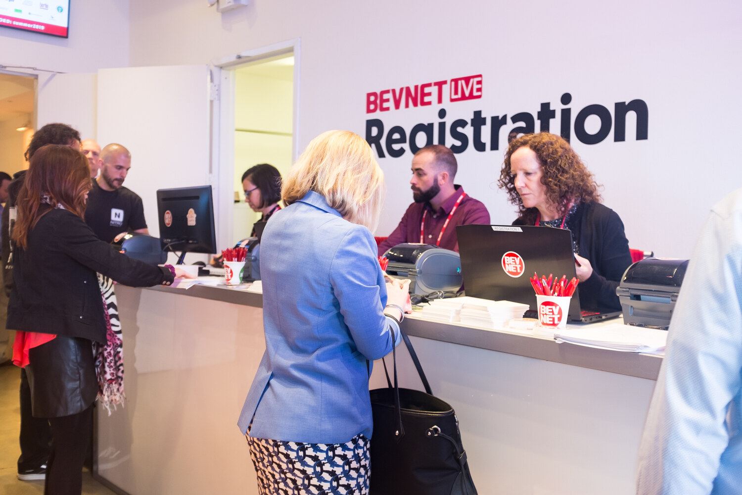 Attendees checking in at the registration counter beneath the BevNET Live Registration sign.