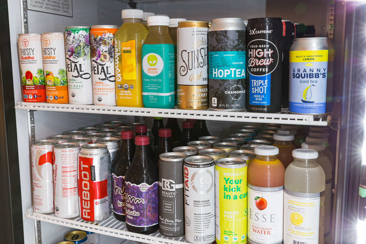 Cooler shelves stocked with Thirsty Buddha, Petal, Sunshine, HopTea and other beverages.