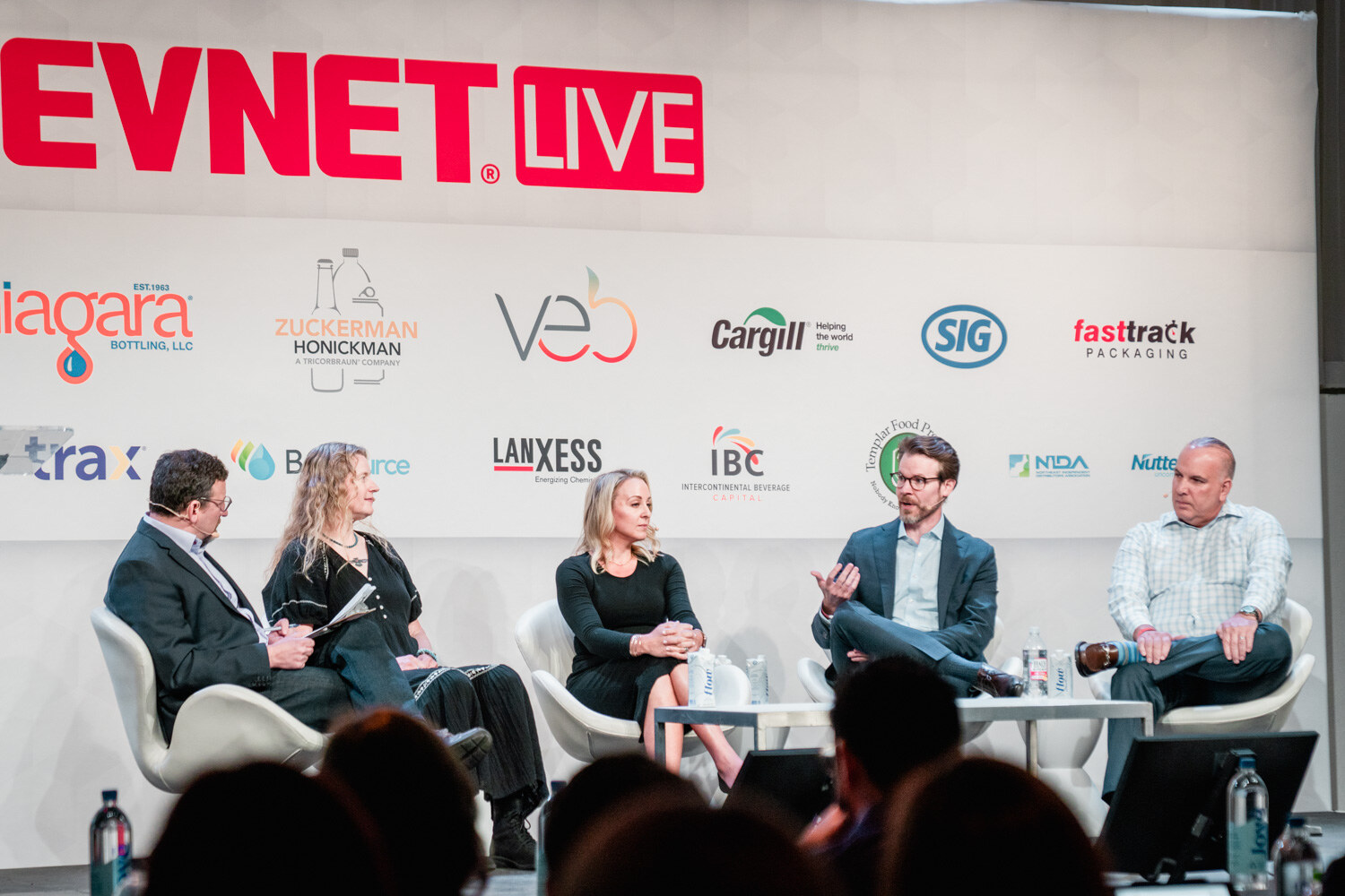 Five people seated across the stage below the BevNET Live sign, with audience heads at the bottom of the frame.
