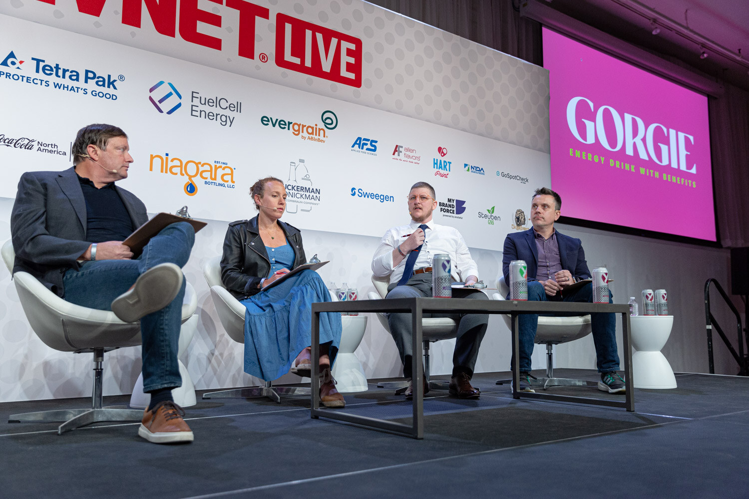 Wide shot of four people seated on a stage under the BevNET Live logo, with a pink screen at right showing the word Gorgie.