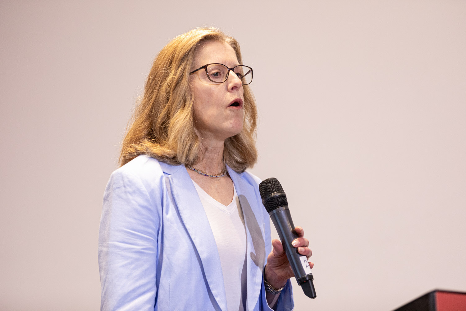 Presenter in a light blue blazer speaks to the Beverage School audience.