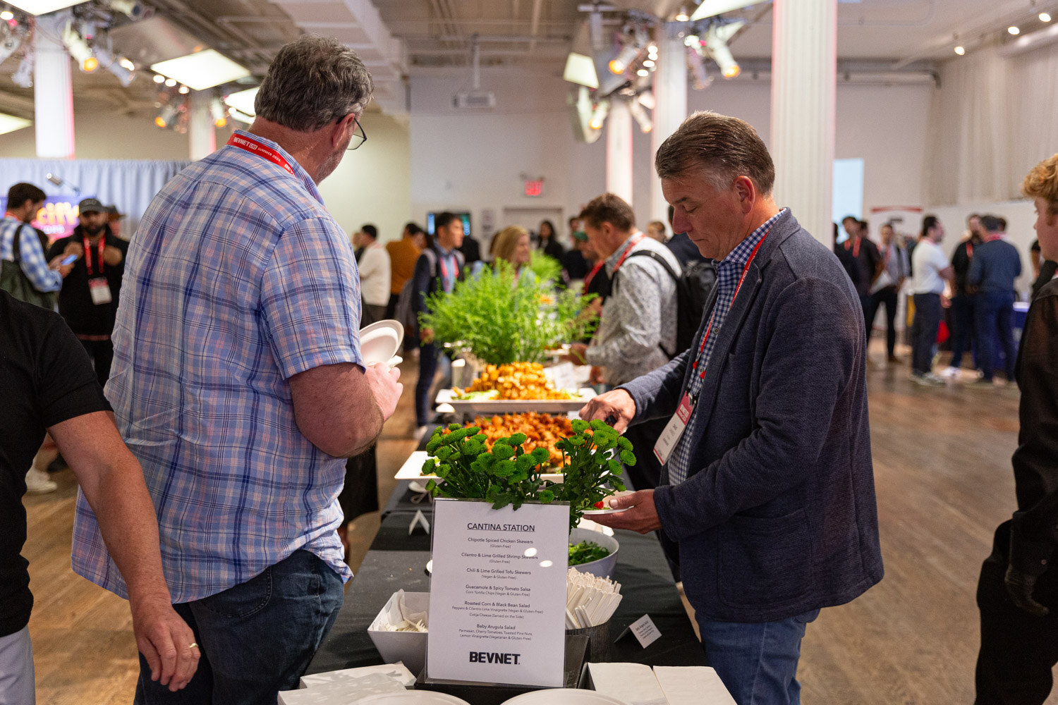 Attendees fill plates at a BevNET catering station in the main room.