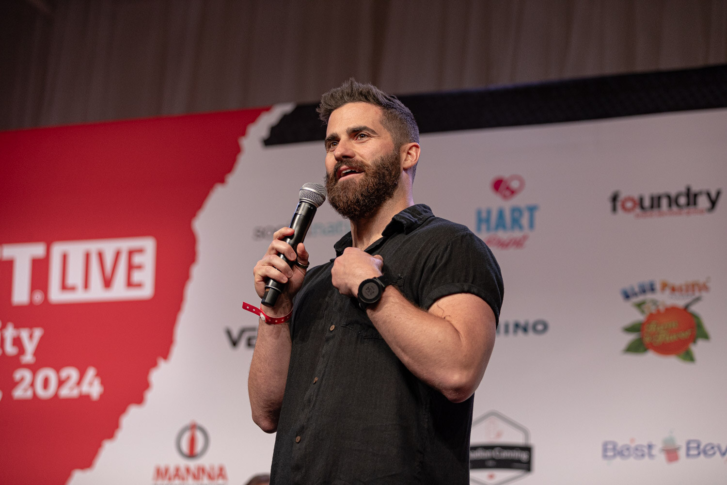 Contestant holding a microphone pitches on the New Beverage Showdown semifinal stage.