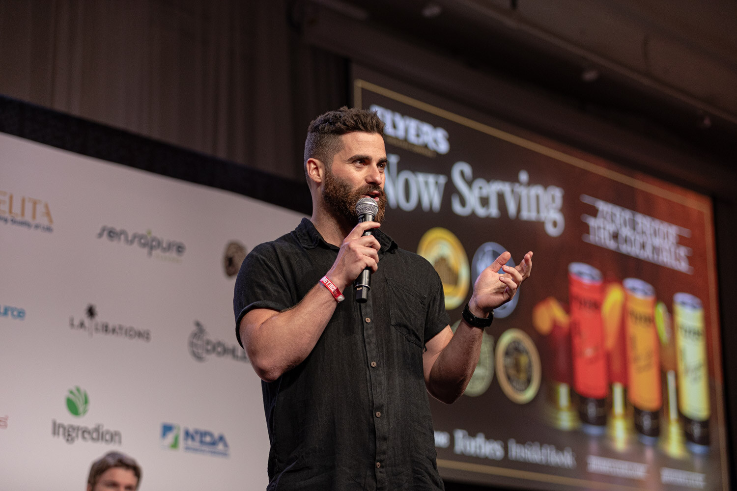 Contestant presents a Now Serving slide with canned cocktails during the semifinals.