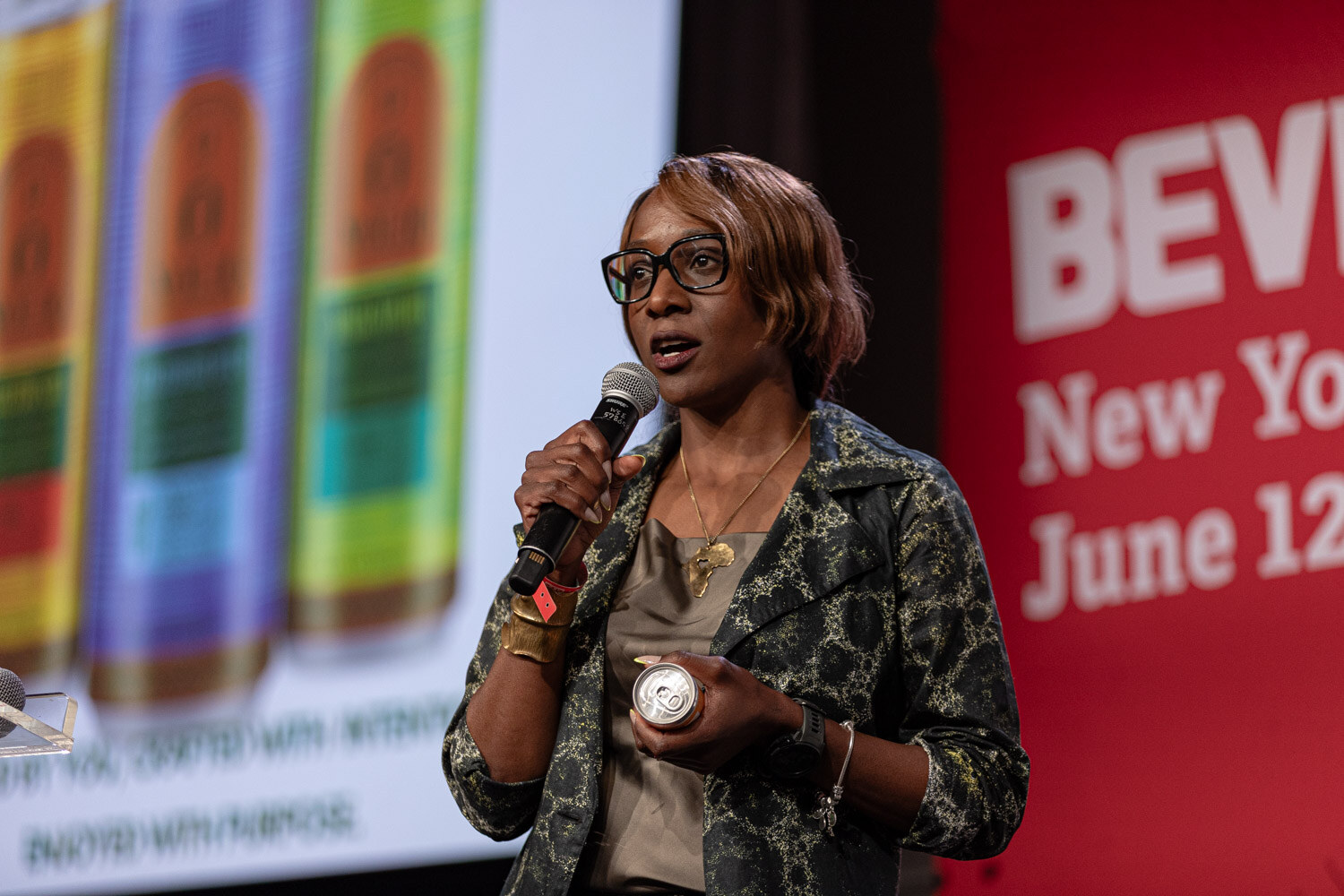Contestant holds a can in front of a slide of colorful striped cans.