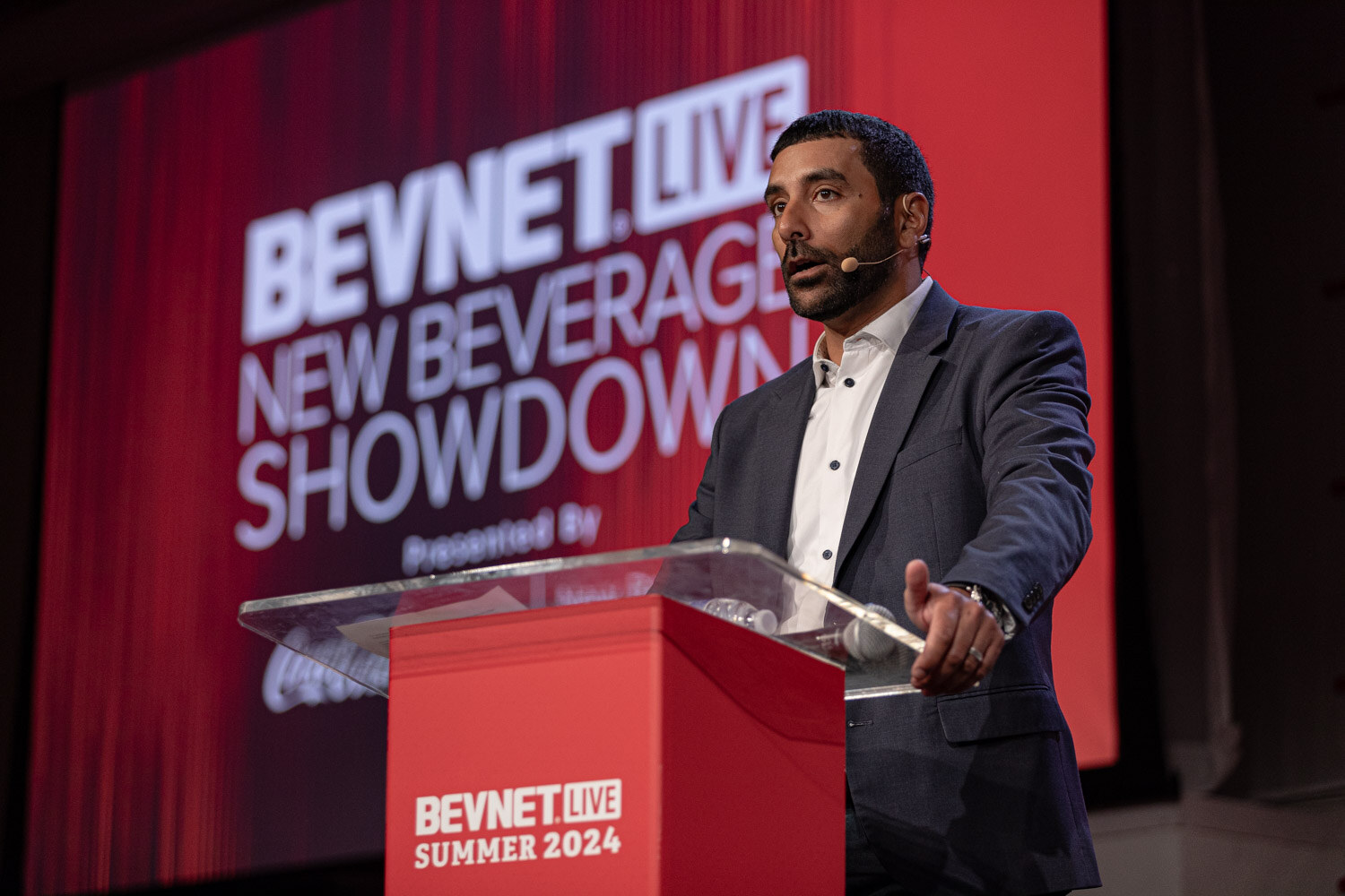 Emcee at the New Beverage Showdown podium introduces the judges.
