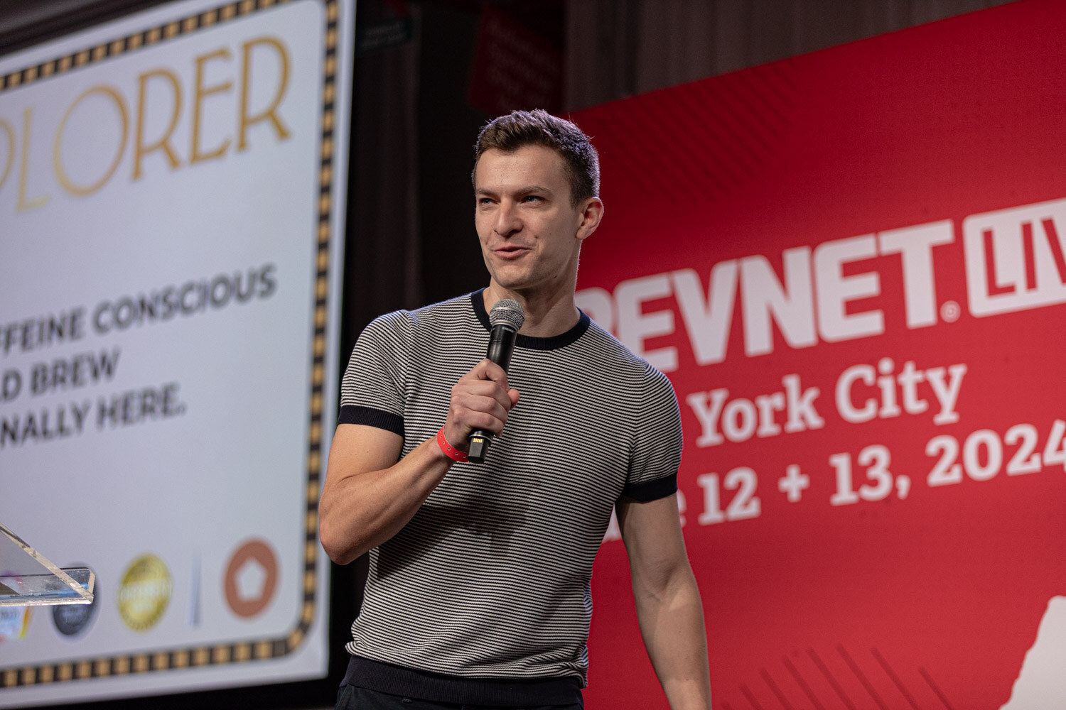 Finalist in a striped t-shirt pitches beside an Explorer cold brew slide.