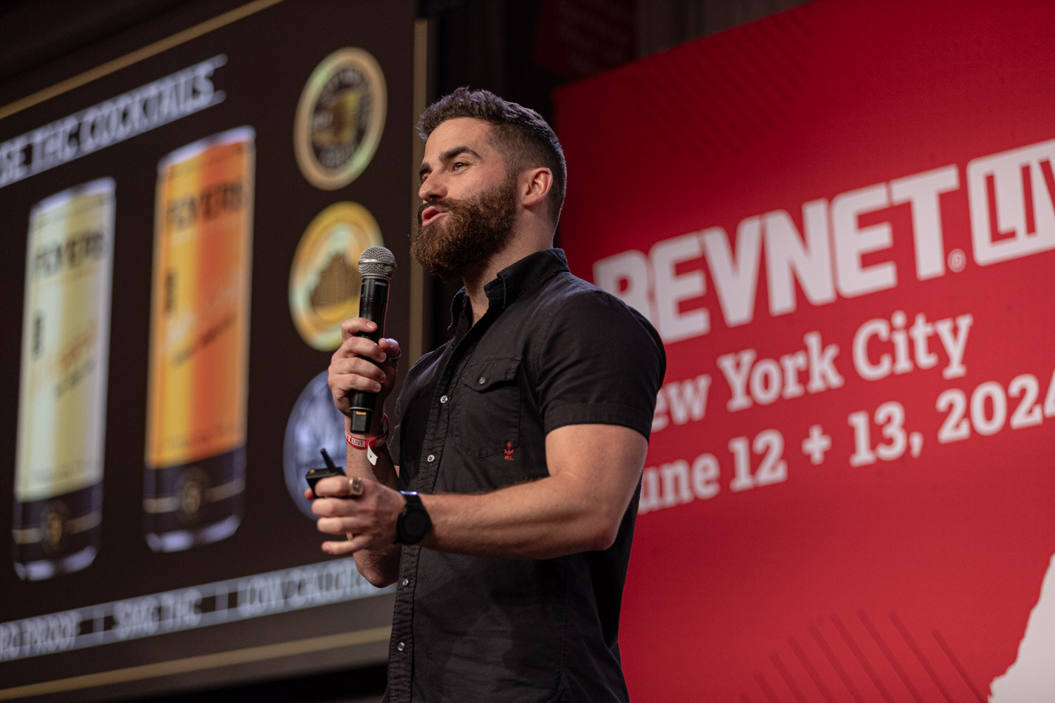 Finalist in a black shirt presents beside a slide of canned cocktails.