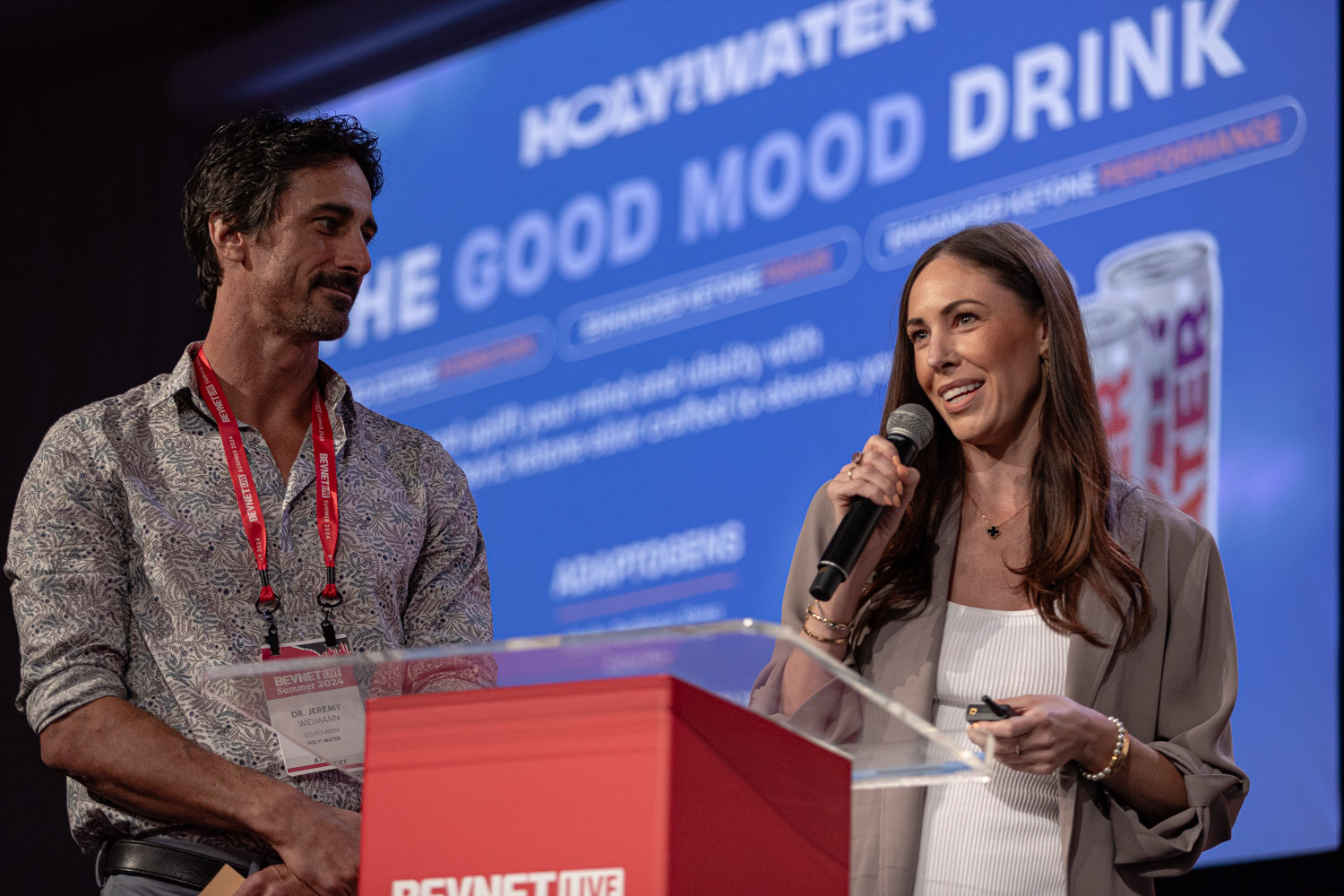 Two finalists at the podium in front of a Holy Water slide.