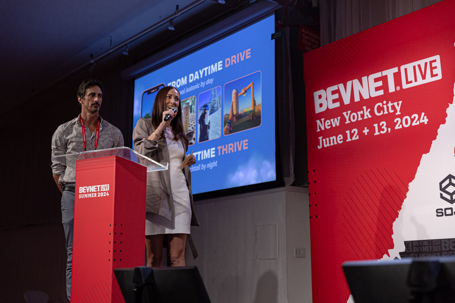 Two finalists at the podium in front of a From Daytime Drive slide.