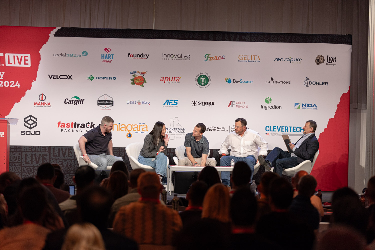 Five panelists and a moderator on the main stage during the State of the Market session.