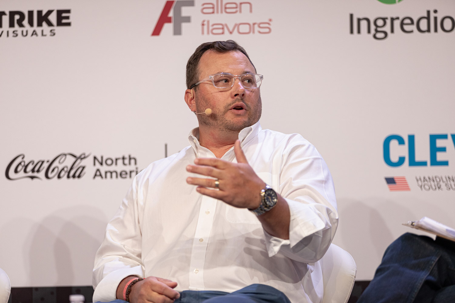 Panelist in a white shirt and clear glasses speaks during State of the Market.