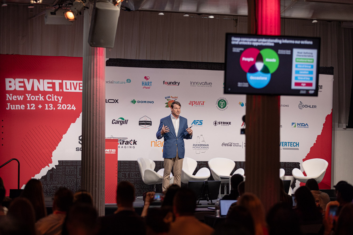 Wide view of the speaker on the main stage with the audience in front.