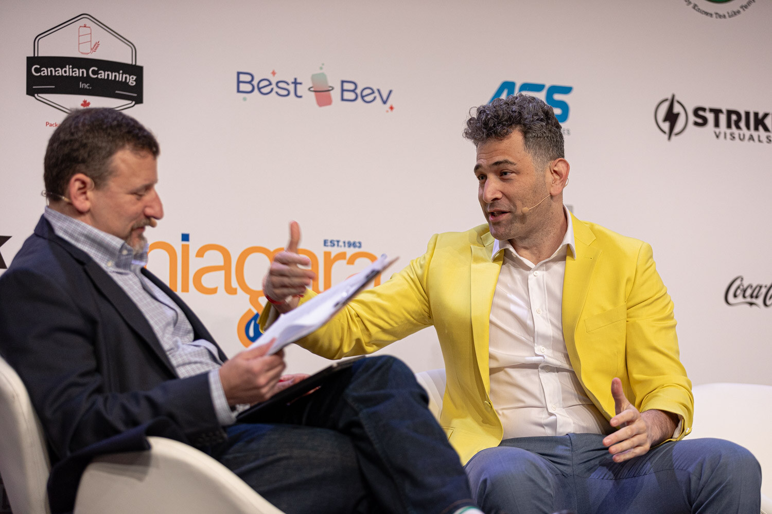 Guest in a yellow jacket gestures toward the moderator during Tough Calls.
