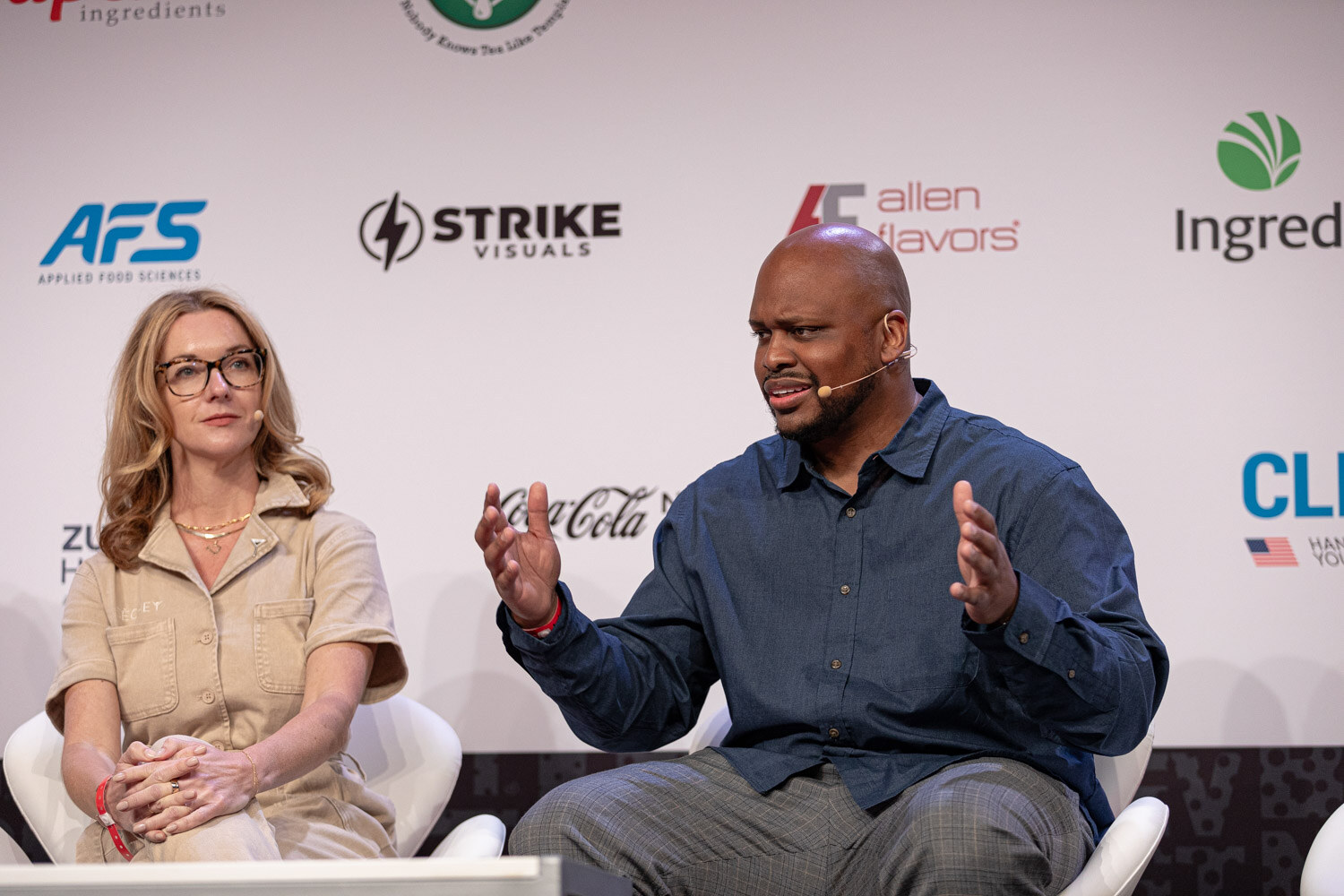 Panelist in a navy shirt and panelist in a tan jumpsuit during Building the Category.