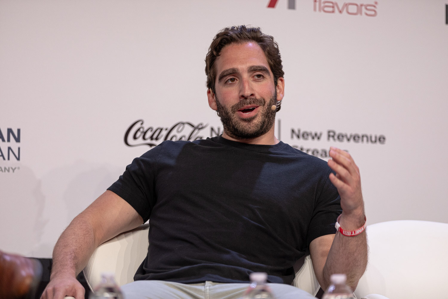 Panelist in a black t-shirt listens during the Sports Marketing session.