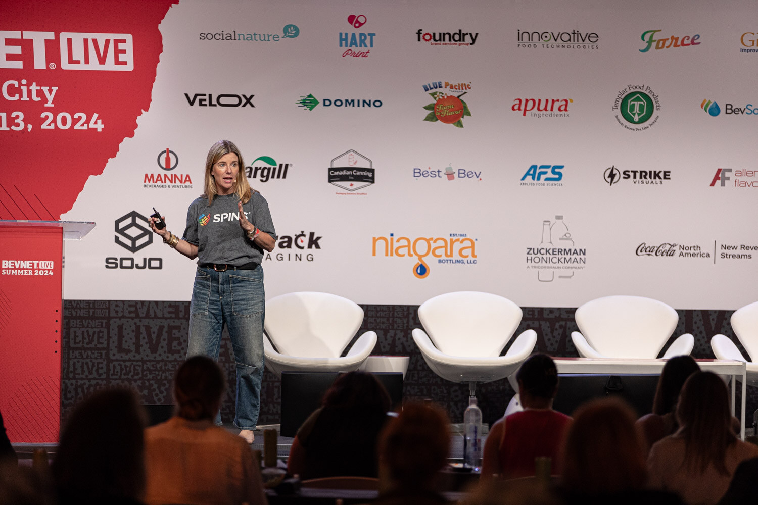Wide view of a speaker in a SPINS t-shirt on the main stage during Data Drive.