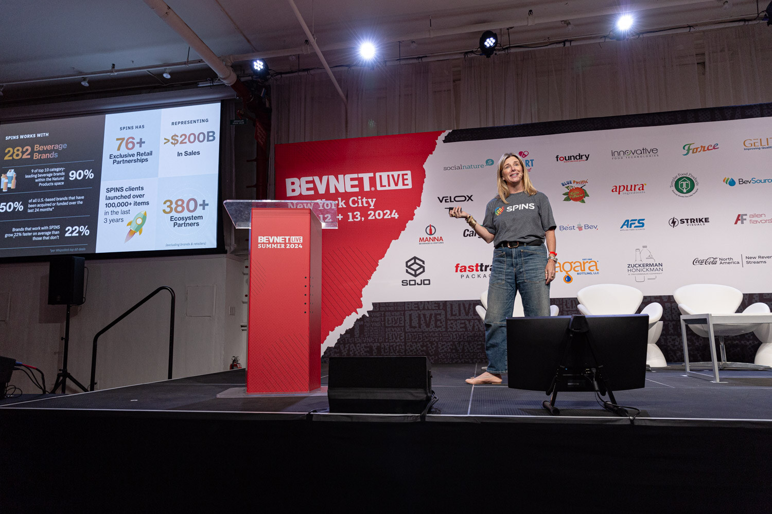 Wide view of the Data Drive speaker walking across the stage in front of slides.