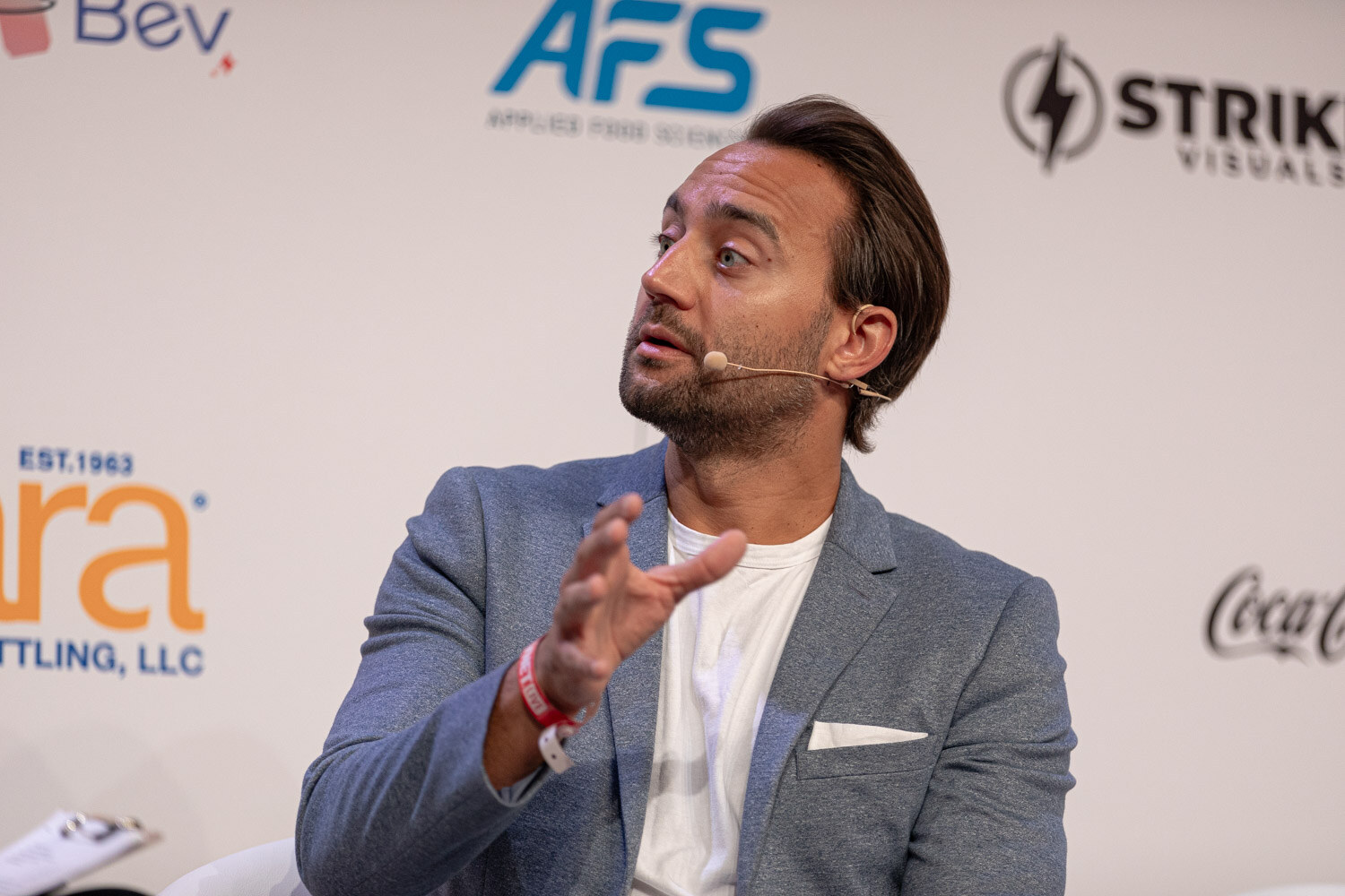 Close view of the guest in a gray blazer looking toward the moderator.