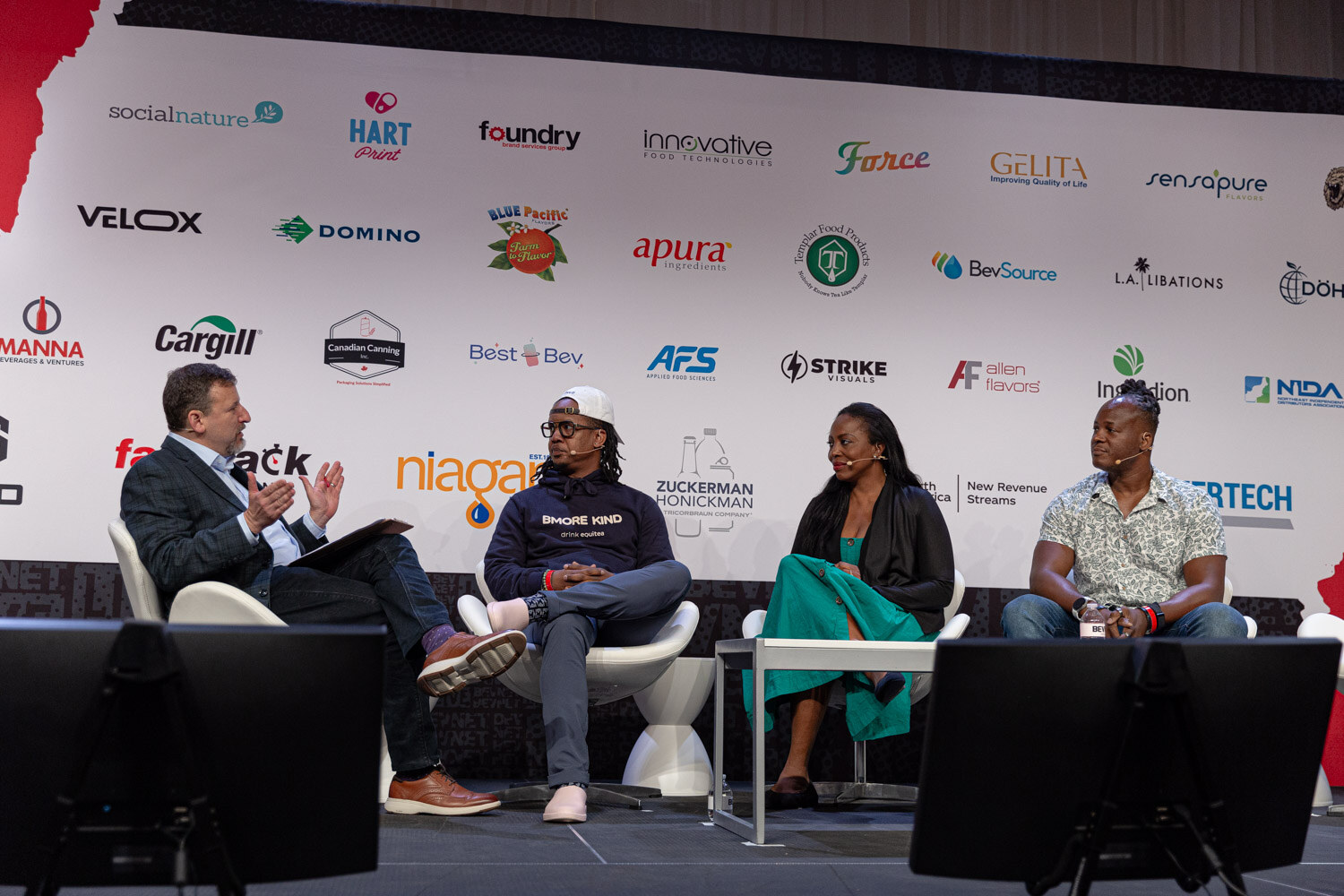 Moderator and three panelists seated on stage during Giant Steps.