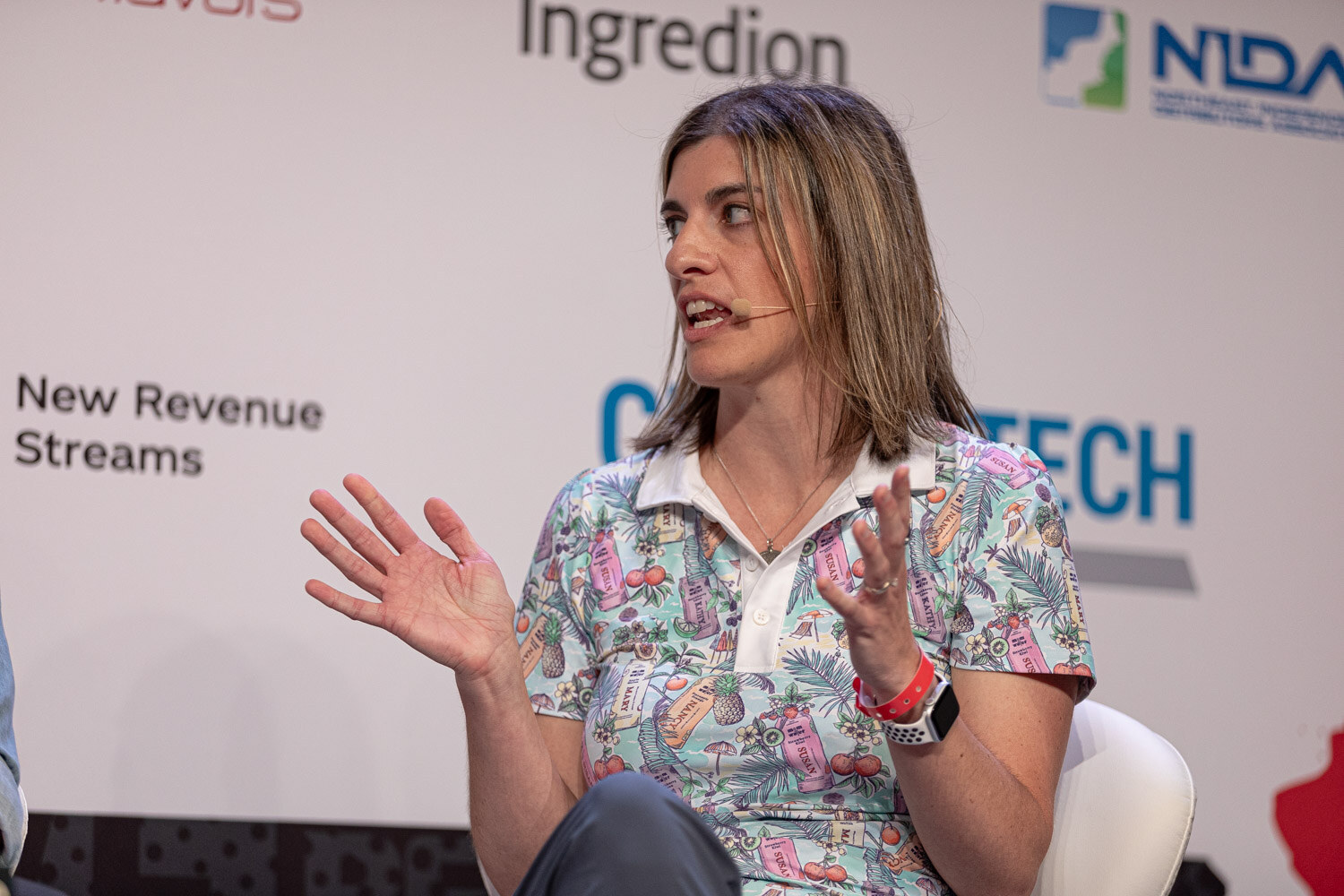 Panelist in a patterned polo gestures with open hands during Spirit World.