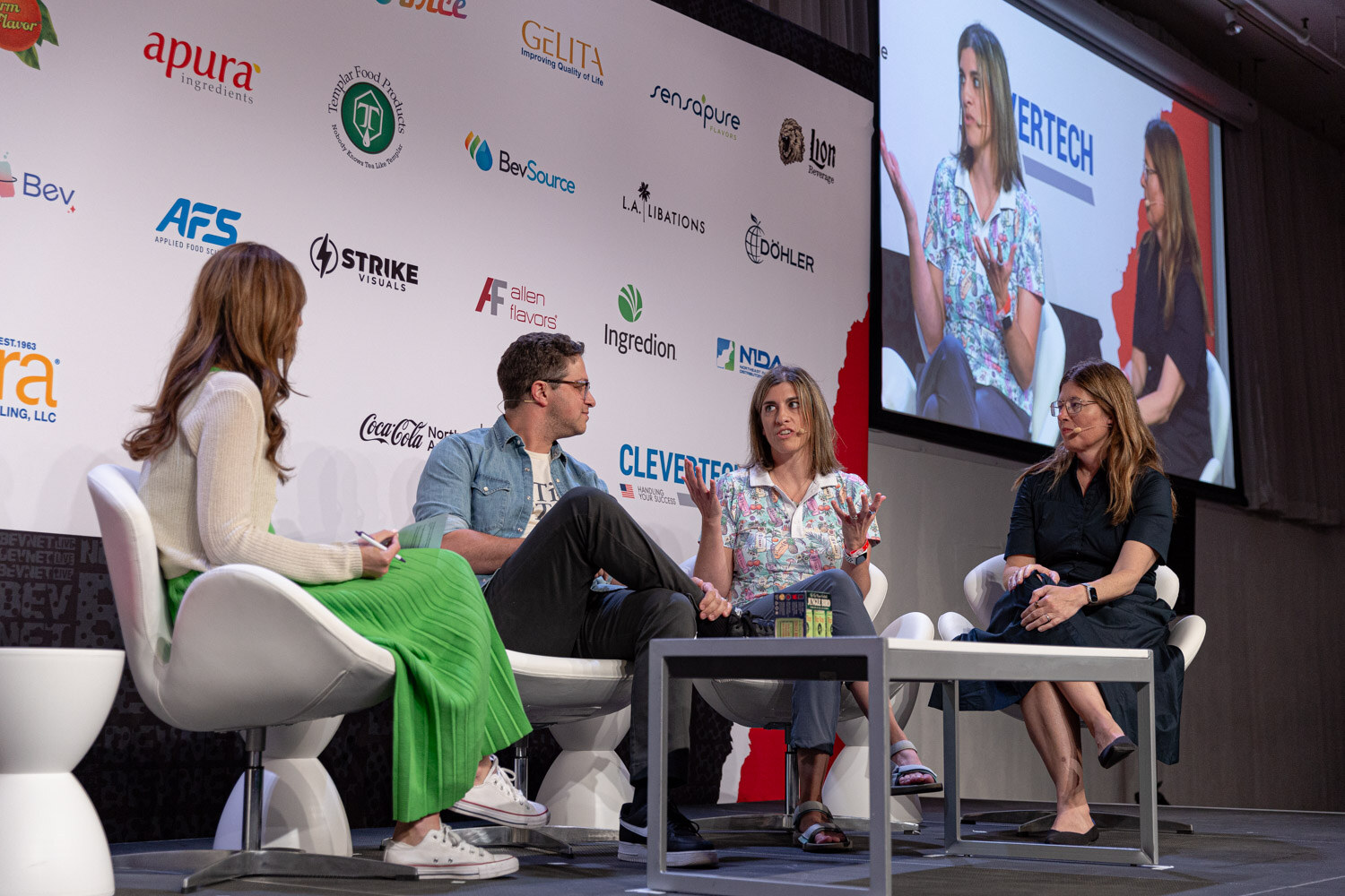 Moderator and three panelists seated on stage during Spirit World.