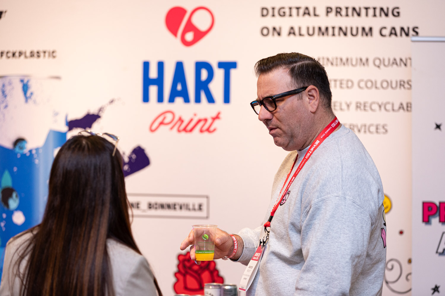 Attendee talks with a representative at the Hart Print digital can printing booth.