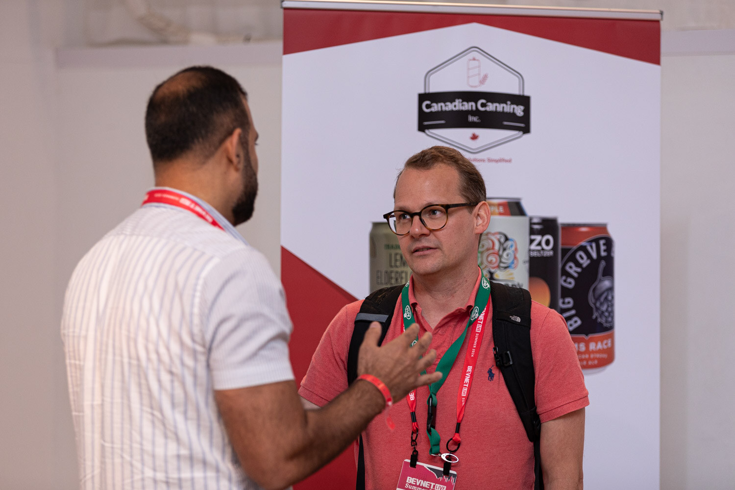 Attendee in a coral polo talks at the Canadian Canning booth.