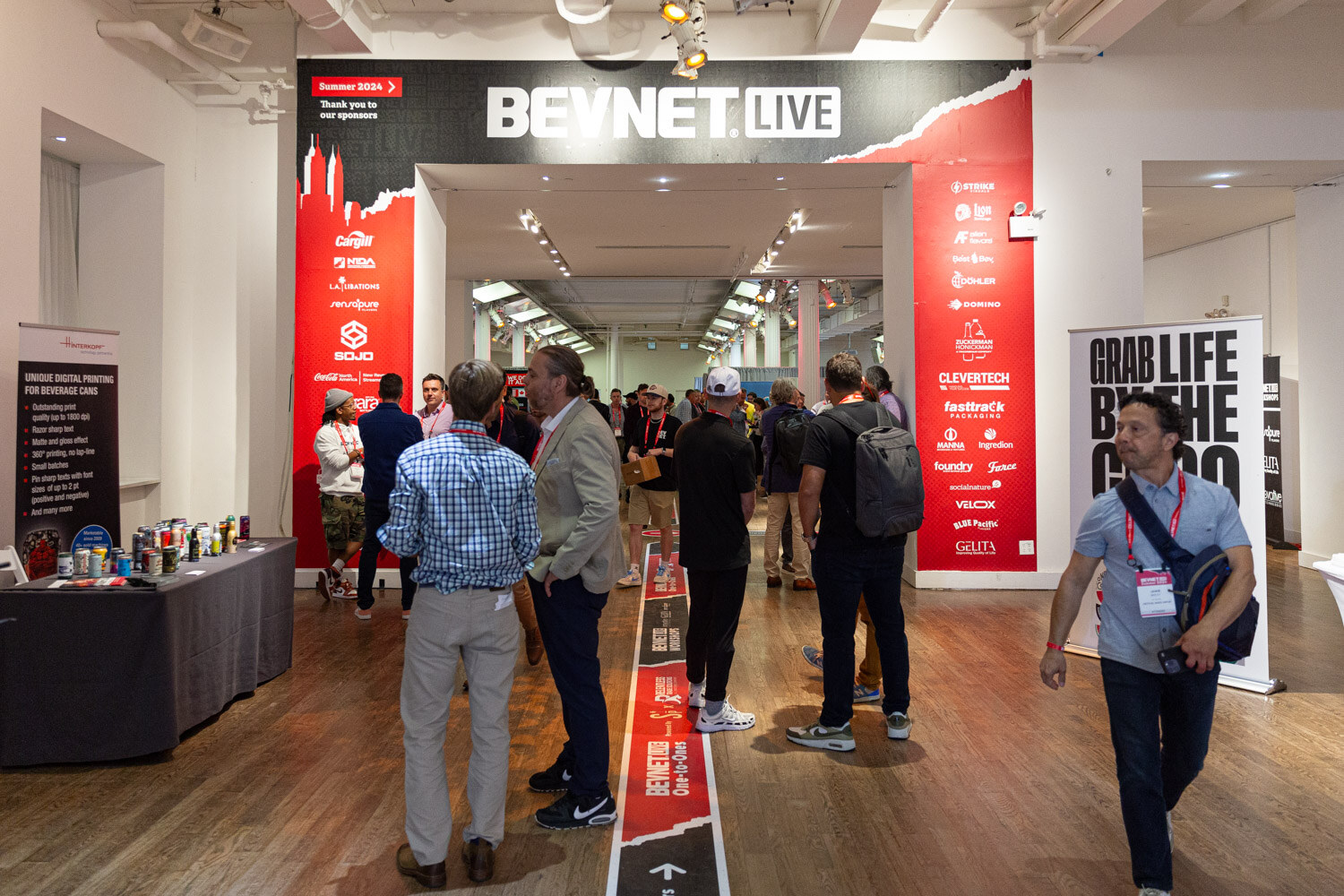 Attendees walk the exhibit hallway under a BevNET Live entrance sign.
