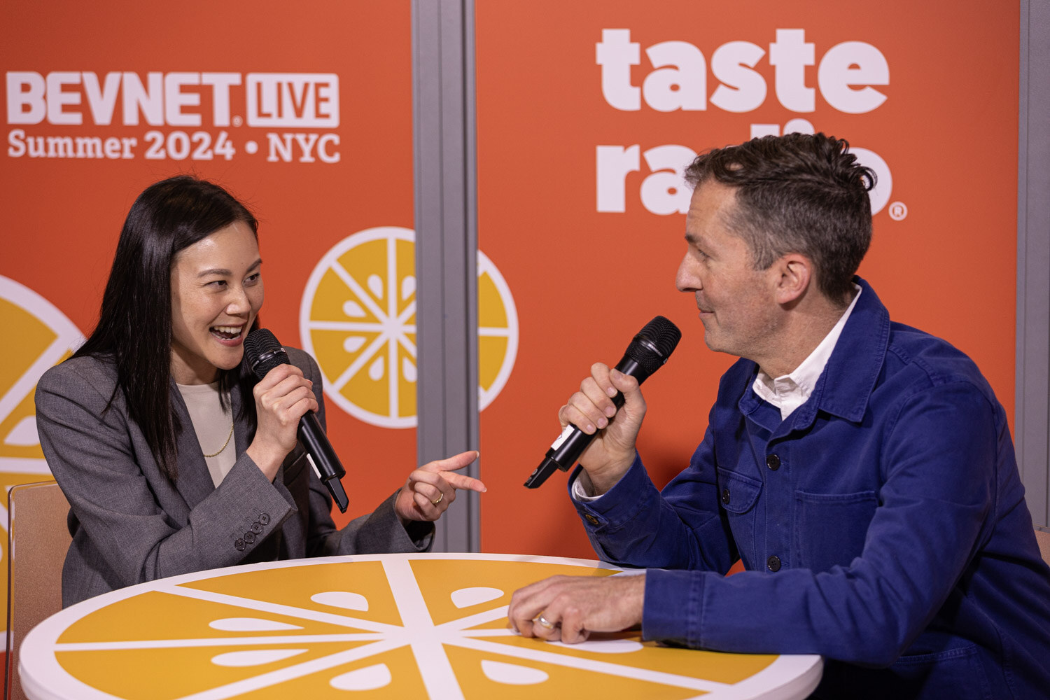 Guest in a gray blazer chats with a host in a blue jacket at the Taste Radio livestream.