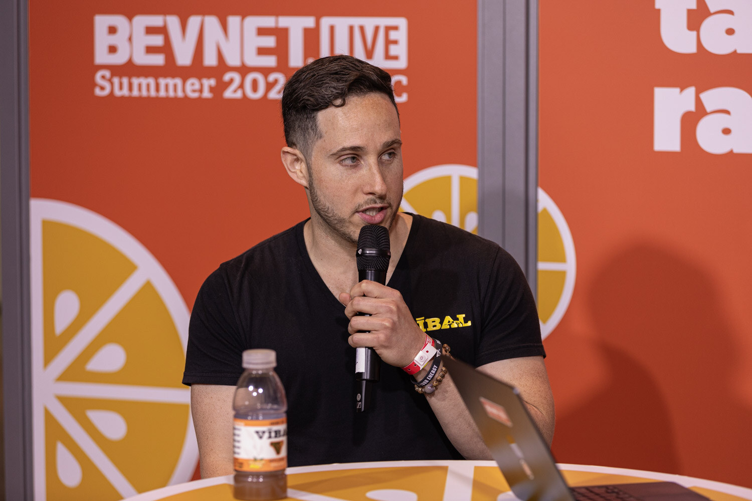 Guest in a black v-neck shirt speaks at the Taste Radio livestream.