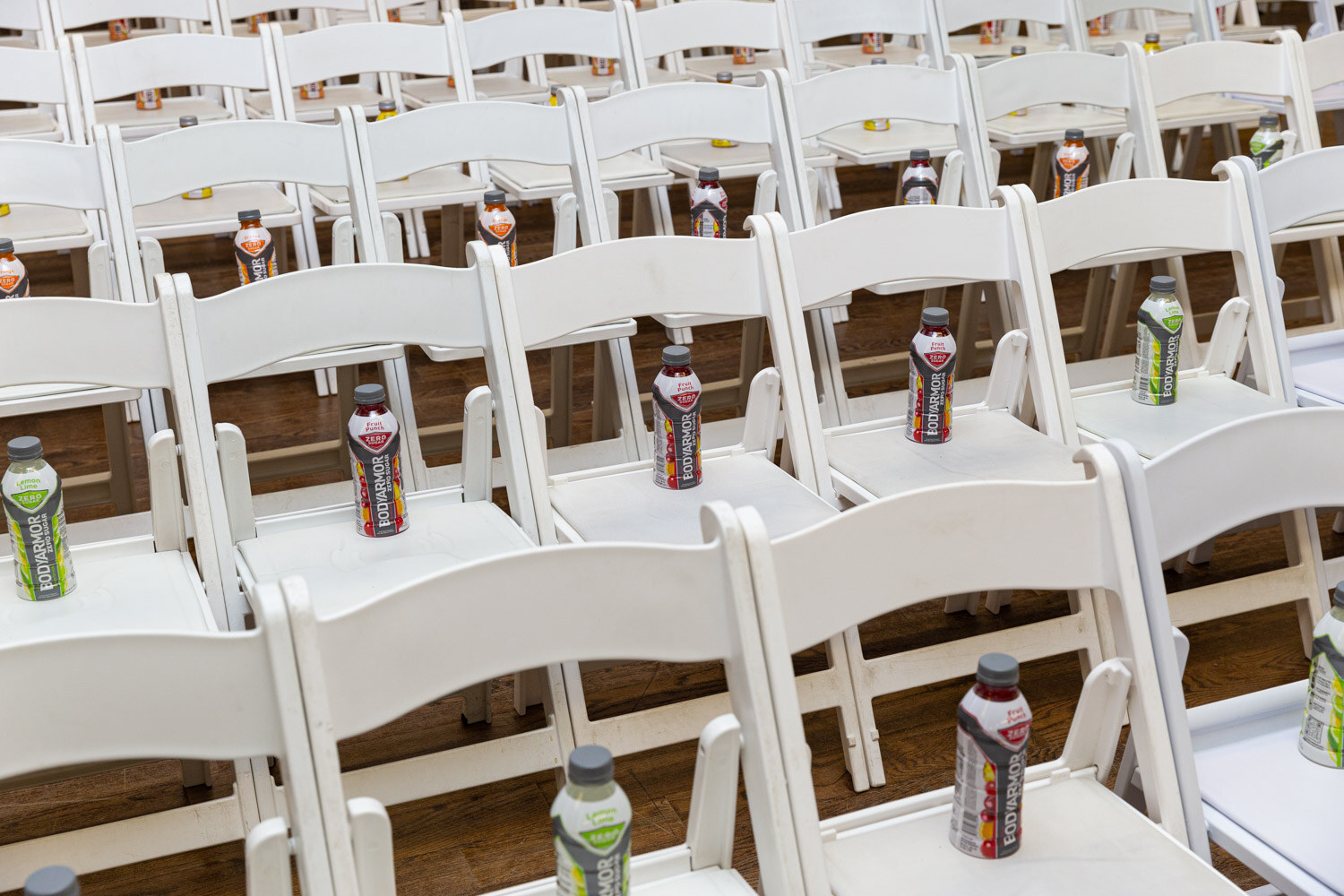 Rows of white chairs set with BODYARMOR bottles before the sessions.
