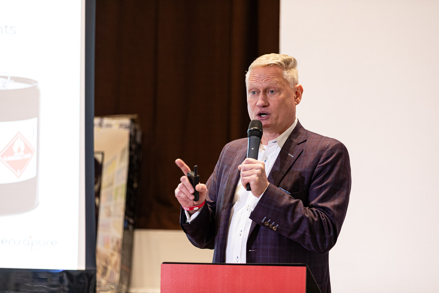 Workshop leader in a plaid blazer holds a microphone beside a slide during the Streamline Bev workshop.