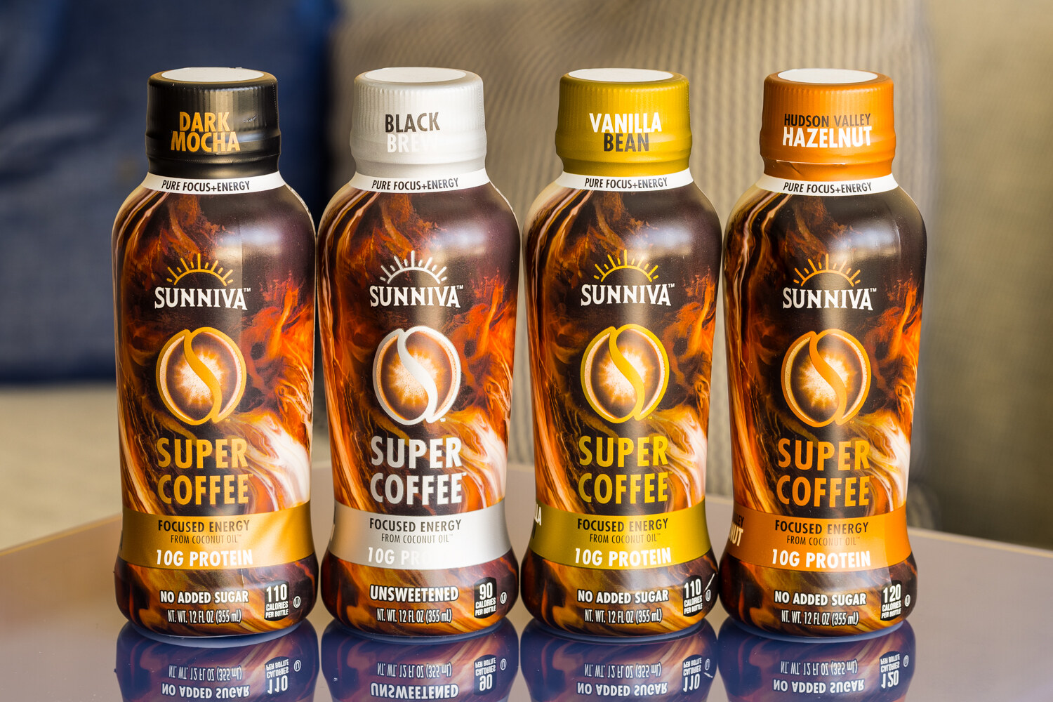Four bottles of Sunniva Super Coffee labeled Dark Mocha, Black, Vanilla Bean and Hudson Valley Hazelnut sit side by side on a reflective surface.