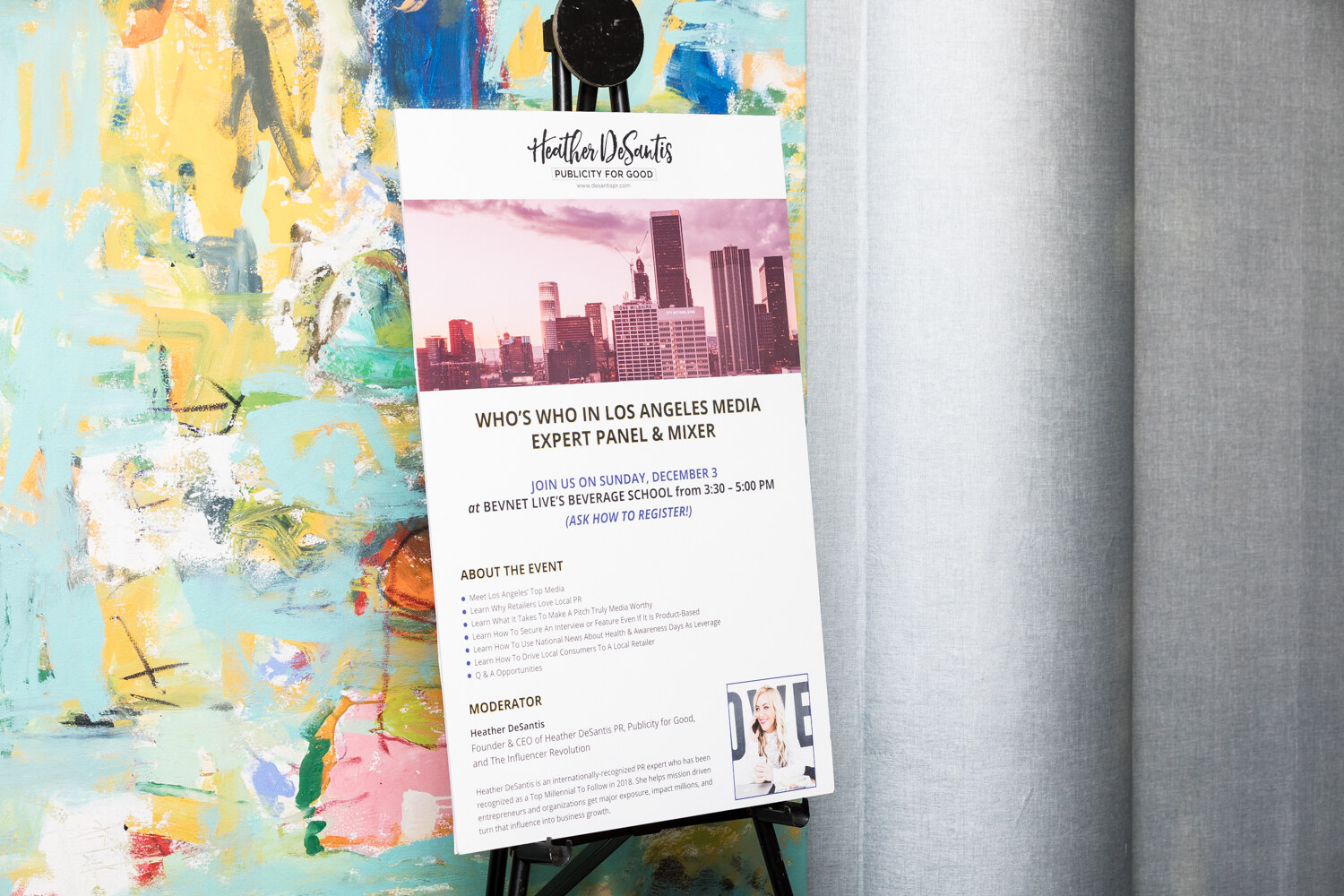A poster on an easel titled Who's Who in Los Angeles Media Expert Panel and Mixer, listing Sunday, December 3 at BevNET Live's Beverage School from 3:30 to 5:00 PM, in front of a painting and gray curtains.