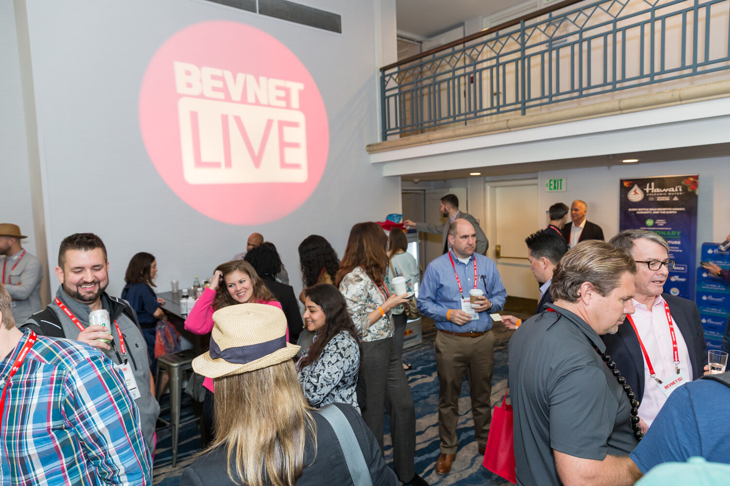 Crowded hotel hall with a projected BevNET Live logo and attendees talking.